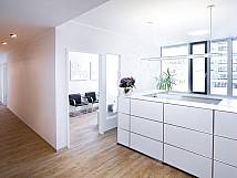 Moderner Empfangsbereich einer Zahnarztpraxis mit großem Tresen, hellem Holzboden und Blick in das Wartezimmer.